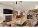 Open-concept living room with hardwood floors, a stone fireplace, and views into the modern kitchen with stainless appliances at 2714 Calmante Pl, Superior, CO 80027