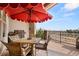 Outdoor dining area on a wood deck, featuring a grill, table and chairs, and scenic views overlooking a pond at 2714 Calmante Pl, Superior, CO 80027
