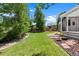Manicured backyard features lawn, mature trees, and inviting patio space at 7472 Iridium Way, Castle Rock, CO 80108