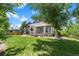 Beautiful backyard with lush green grass, mature trees, and a charming pergola-covered patio at 7472 Iridium Way, Castle Rock, CO 80108