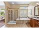Bathroom featuring a glass enclosed shower, soaking tub, and vanity area at 7472 Iridium Way, Castle Rock, CO 80108