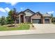 Charming brick home featuring a well-manicured lawn and a three-car garage at 7472 Iridium Way, Castle Rock, CO 80108