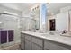 Bright bathroom featuring double sinks, quartz countertop, and a glass enclosed shower at 5121 N Yampa St, Denver, CO 80249