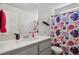 Well-lit bathroom featuring a floral shower curtain, white countertop, and a large mirror at 5121 N Yampa St, Denver, CO 80249