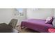 This bedroom features a cozy single bed with a purple comforter and a comfortable chair at 5121 N Yampa St, Denver, CO 80249