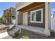 Home exterior featuring a covered entrance, gray siding, and small landscaped area at 5121 N Yampa St, Denver, CO 80249