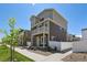 Two-story home with gray and beige siding, white trim, and small balcony over front door at 5121 N Yampa St, Denver, CO 80249