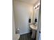Cozy powder room featuring a pedestal sink, mirror, and toilet at 5121 N Yampa St, Denver, CO 80249