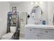 Cozy bathroom featuring a gray vanity, round mirror, and convenient over-the-toilet storage at 8452 Everett Way # C, Arvada, CO 80005