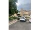 A well-maintained townhome with a stone chimney, visible parking, and green space at 8452 Everett Way # C, Arvada, CO 80005