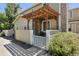 Charming front porch with a wooden pergola, cozy seating, and attractive landscaping at 8452 Everett Way # C, Arvada, CO 80005