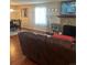 Open living room with a fireplace, TV, hardwood floors, and a comfortable brown leather couch at 8452 Everett Way # C, Arvada, CO 80005