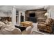 Open basement with living area, entertainment center, and wood-paneled accent wall at 16120 E 119Th Ave, Commerce City, CO 80022
