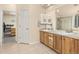Bathroom features double sinks, wooden cabinetry, tile floors, and walk in shower with glass doors at 16120 E 119Th Ave, Commerce City, CO 80022