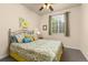 Comfortable bedroom with a patterned bedspread, soft lighting, and a window overlooking the backyard at 16120 E 119Th Ave, Commerce City, CO 80022
