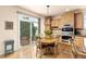 Bright eat-in kitchen area with wood cabinetry, access to the backyard, and stylish pendant lighting at 16120 E 119Th Ave, Commerce City, CO 80022