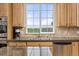 Close-up of the kitchen window with stainless steel sink, appliances, granite counters, and outside views at 16120 E 119Th Ave, Commerce City, CO 80022
