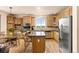 Bright kitchen featuring light wood cabinets, stainless steel appliances, and a center island with granite countertops at 16120 E 119Th Ave, Commerce City, CO 80022