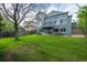 Large grassy backyard of a two-story home featuring a deck, hot tub, and mature trees in a Gathering neighborhood at 1874 Cedaridge Cir, Superior, CO 80027