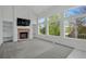 Bright living room with a cozy fireplace and expansive windows offering scenic views at 1874 Cedaridge Cir, Superior, CO 80027