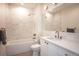 Modern bathroom with a tub-shower combo, sleek vanity, updated fixtures and neutral wall tiling at 3530 Fenton St, Wheat Ridge, CO 80212