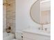 Modern bathroom featuring a tub-shower combo, vanity, round mirror, and updated fixtures at 3530 Fenton St, Wheat Ridge, CO 80212