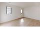 Bright bedroom with hardwood floors, two windows letting in ample natural light, and fresh white walls at 3530 Fenton St, Wheat Ridge, CO 80212