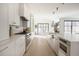 Modern kitchen featuring white cabinets, stainless steel appliances, and an open layout to dining area at 3530 Fenton St, Wheat Ridge, CO 80212