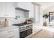 Stylish kitchen featuring stainless steel appliances, white cabinets, and marble backsplash at 3530 Fenton St, Wheat Ridge, CO 80212