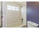 A full bath with white tiles, a tub, a window, and a toilet at 1771 W 53Rd Pl # 2, Denver, CO 80221