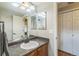 Bathroom featuring a wide mirror, updated vanity, and a convenient linen closet for ample storage at 1771 W 53Rd Pl # 2, Denver, CO 80221