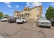 Attractive tan apartments with brick accents, balconies, and parking on a partly cloudy day at 1771 W 53Rd Pl # 2, Denver, CO 80221