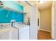 Bright laundry room with modern washer and dryer, shelving, and an organized layout for efficient use at 1771 W 53Rd Pl # 2, Denver, CO 80221