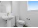 Well-lit half bathroom featuring a pedestal sink, modern fixtures, and a clean, minimalist design at 14261 Currant St, Broomfield, CO 80020