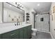 This is a bathroom with a large mirror, green vanity, and glass shower at 17692 E Brunswick Pl, Aurora, CO 80013