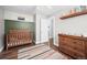 This is a bedroom or Bedroom with a crib, dresser, shelf, and a rug at 17692 E Brunswick Pl, Aurora, CO 80013