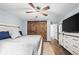 The bedroom features beautiful barn doors, hardwood floors, and a ceiling fan at 17692 E Brunswick Pl, Aurora, CO 80013