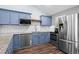 Stylish kitchen with modern appliances, blue cabinets, and a view of the bright and airy dining area at 17692 E Brunswick Pl, Aurora, CO 80013