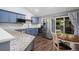 Well-appointed kitchen with stainless steel appliances, blue cabinets, and convenient access to the dining area at 17692 E Brunswick Pl, Aurora, CO 80013