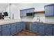 Elegant kitchen with blue cabinets, granite countertops, stainless steel appliances, and modern finishes at 17692 E Brunswick Pl, Aurora, CO 80013