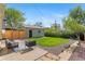 Spacious backyard with a cozy patio area, lush lawn, and a detached garage at 949 Pontiac St, Denver, CO 80220