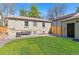 Well-maintained backyard with green lawn, patio space, and a charming detached garage at 949 Pontiac St, Denver, CO 80220