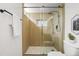 Contemporary bathroom showcases a glass-enclosed shower with wood accents, complemented by hexagon tile flooring at 949 Pontiac St, Denver, CO 80220