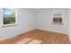 Bright bedroom featuring gleaming hardwood floors, two windows, and neutral walls at 949 Pontiac St, Denver, CO 80220