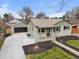 Home with a detached garage, driveway, and tidy front yard at 949 Pontiac St, Denver, CO 80220