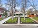 Charming single-story home featuring a manicured front yard and mature trees on a sunny day at 949 Pontiac St, Denver, CO 80220