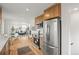 Modern kitchen features stainless steel appliances, wood cabinets, and opens to the living room at 949 Pontiac St, Denver, CO 80220