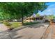 Ranch-style home with a mature tree in the front yard, offering shade and charm, complemented by a long concrete driveway at 7310 Granada Rd, Denver, CO 80221