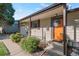 Inviting front porch featuring a bright orange door and lovely landscaping with a cute welcome sign at 7310 Granada Rd, Denver, CO 80221