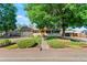 Charming ranch-style home with a well-manicured lawn and a mature tree, perfect curb appeal with an orange front door at 7310 Granada Rd, Denver, CO 80221